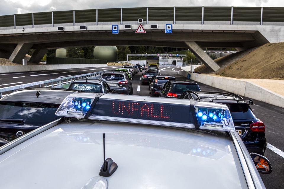 Polizeifahrzeug mit Unfall-Anzeige und Blaulicht auf der Autobahn
